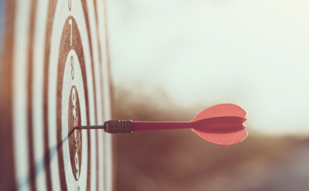 A dart sits in the bullseye of a target.
